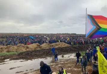 sur un terrain boeux de nombreux manifestants dont certains tiennet des drapeaux