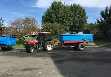 Tracteur avec une benne dans la cour d'une coopérative.