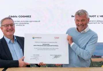 deux hommes assis montrent à l'objectidf un document