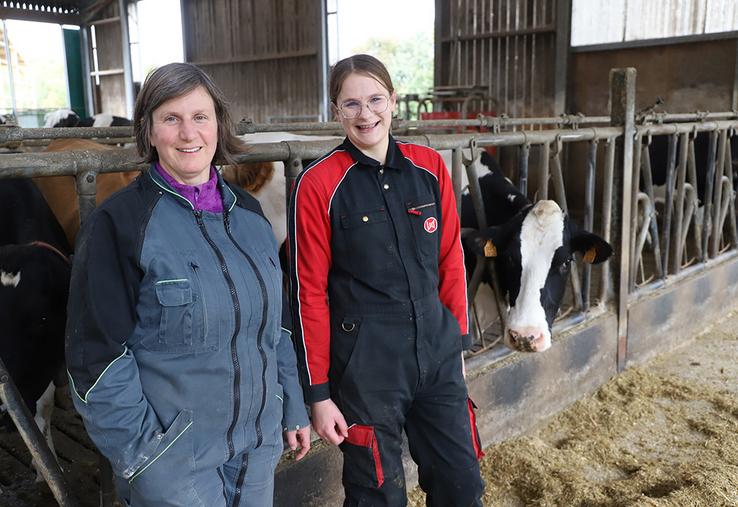 Céline Hérault (à gauche) et sa fille, devant les 100 vaches laitières que compte l’exploitation.
