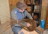 Dans son atelier, Raynald Delattre travaille sur une sellette de vannier (établi de genoux) qu'il a lui-même perfectionnée pour faire pivoter ses pièces. 