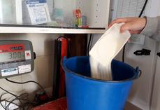 La quantité d'aliment d'allaitement ajoutée est pesée ou bien étalonnée avec un ustensile.