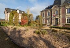 Un massif arbustif paillé avec du miscanthus dans une commune de Seine-Maritime.