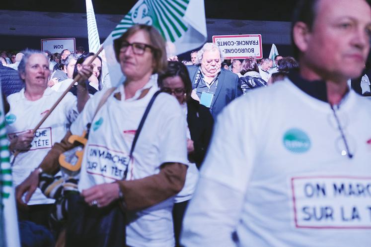 Les congressistes arborant le tee-shirt "on marche sur la tête" et brandissant des panneaux signalétiques à l'envers lors du congrès de la FNSEA.