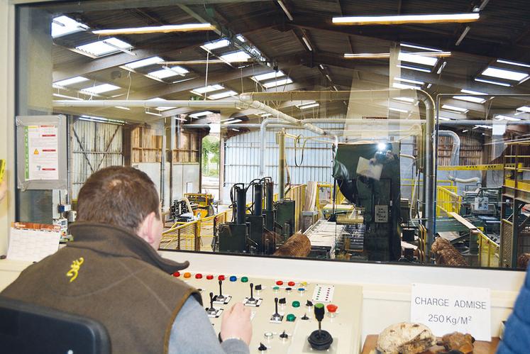 Grâce à un système de commande, les élèves pilotent une écorceuse à bois pour retirer les écorces du tronc.