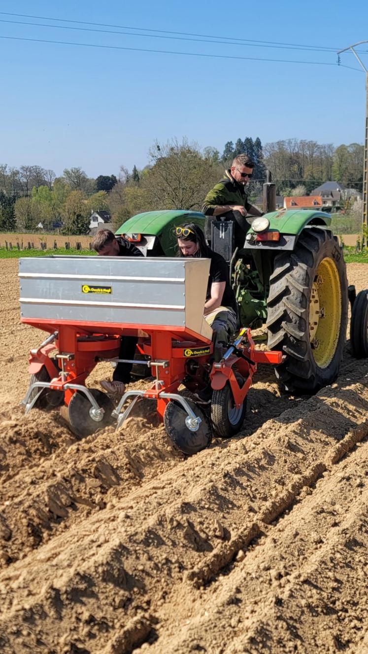 Ludovic Jourdain à la manœuvre avec sa planteuse à pommes de terre, accompagné de deux participants de l'opération "Tous aux agris !", venus mettre les mains dans la terre pour découvrir la réalité du maraîchage bio.