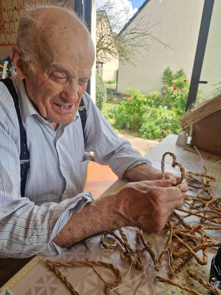 Jean Bauchet en train de confectionner un cœur en lin.