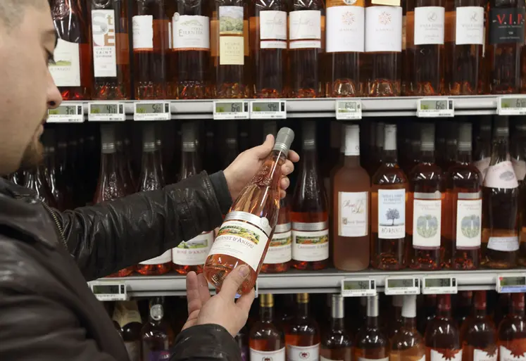 <em class="placeholder">client de supermarché dans un rayon vins. Grande distribution. magasin Carrefour. jeune consommateur dans une grande surface. choix d'un vin rosé cabernet d'anjou. achat ...</em>