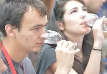 Jeune homme et jeune femme  en dégustation de vin rouge à Bordeaux fête le vin. Appréciation des arômes. Odorat. Nez. Saveur. Consommation de vin.  Verres.