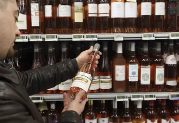 <em class="placeholder">client de supermarché dans un rayon vins. Grande distribution. magasin Carrefour. jeune consommateur dans une grande surface. choix d'un vin rosé cabernet d'anjou. achat ...</em>