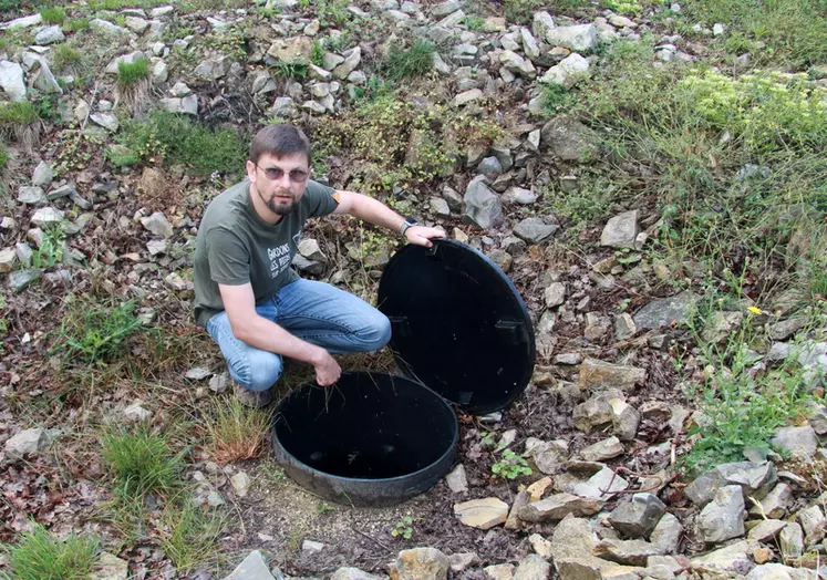 Au pied de la poche souple, Sylvain nettoie régulièrement le filtre des particules grossières pour que l'eau ne parte par le trop-plein.